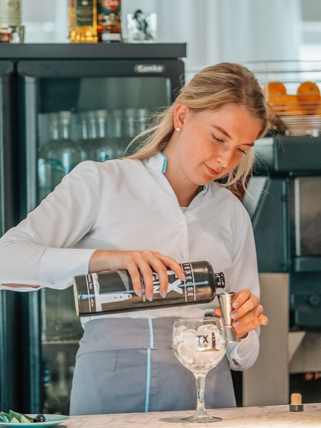 Medewerker schenkt een drankje achter de bar
